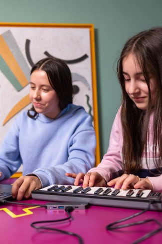 Leerlingen in klaslokaal met klein keyboard en laptop