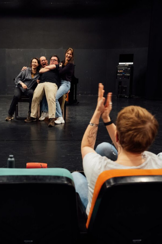 Cursisten in theaterzaal spelen scene voor publiek