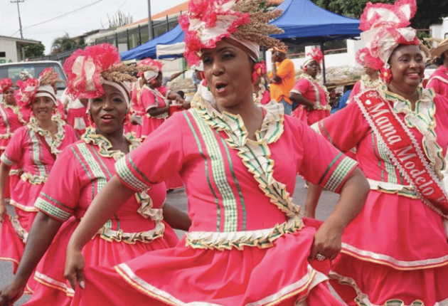 Dansende vrouwen gekleed in traditionele Curaçaose kleding.