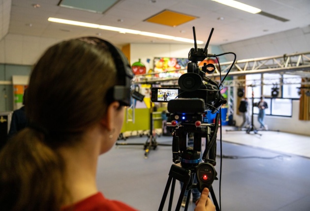 Leerling bedient videocamera
