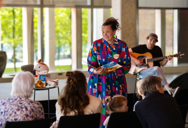 Er wordt een boek voorgelezen met muziek als ondersteuning