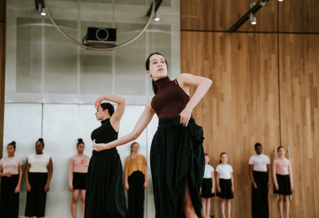 Dansers in een grote ruimte.