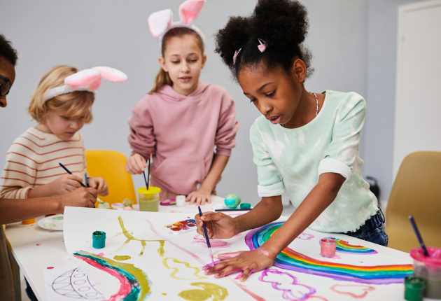 Meerdere kinderen werken aan een schilderij